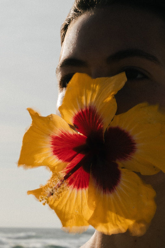 Person eating a flower but wondering: Balm Cleansing vs Oil Cleansing: which is better?