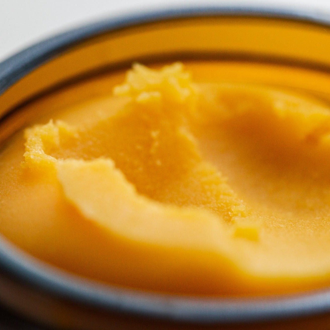 Solid golden cleansing balm with a mousse texture melts on skin contact